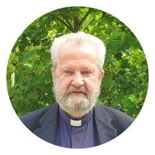 Picture of Fr. Frank McDevitt with tree in background